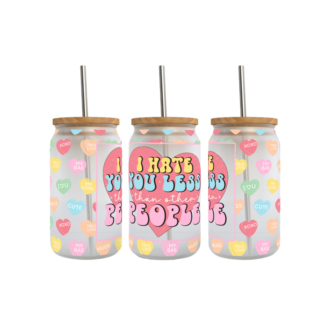 Three frosted glass cans with wooden lids, featuring colorful designs with hearts and text that reads 'I HATE YOU LESS THAN OTHER PEOPLE'.